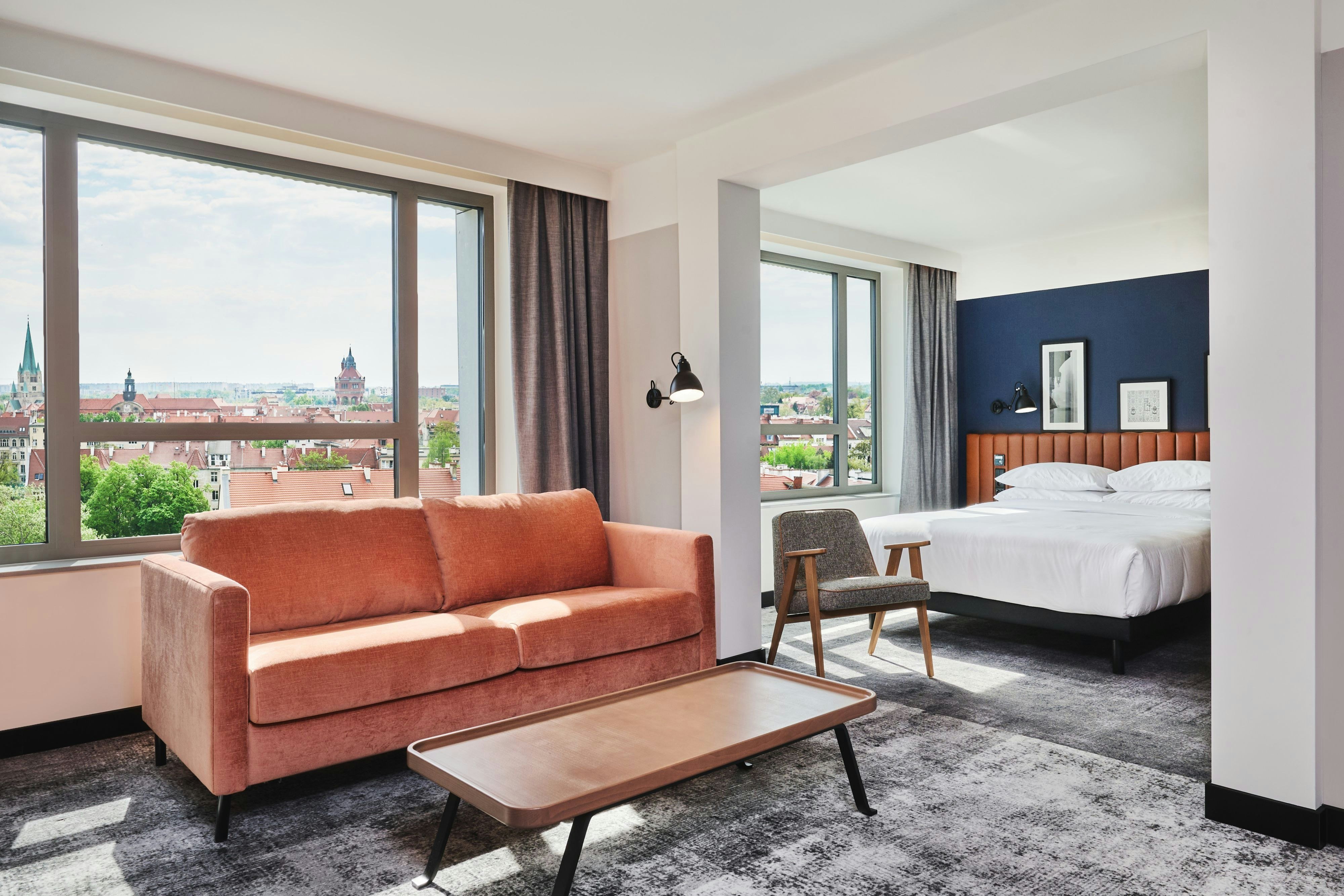 Four Points by Sheraton Wroclaw-guestroom-Guest room with king bed, sofa and city view.jpg