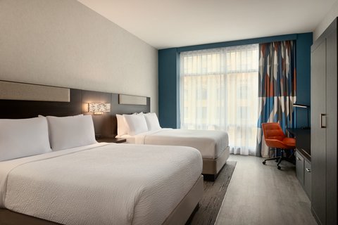 Two Queen guest room with workspace in downtown Houston.