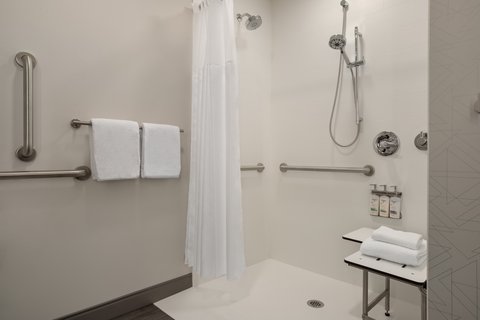 Accessible guest shower with grab bars in downtown Houston.