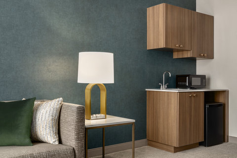 Hotel suite with a kitchenette, microwave, and seating area.