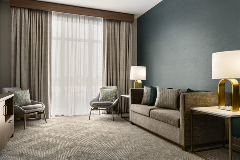 One bedroom suite living area with a sofa and bright windows.