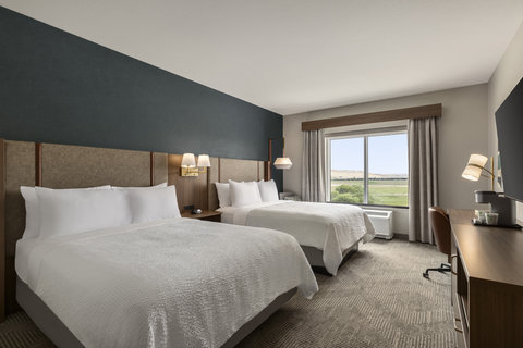 Two queen bed room with a work desk and comfortable seating.