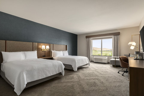 Mobility accessible room with two queen beds and a work desk.