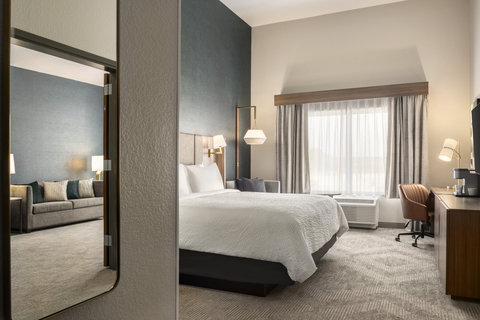One bedroom suite with a king bed and a dedicated workspace.