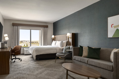 King suite with a king bed, sofa lounge, and bright workspace.