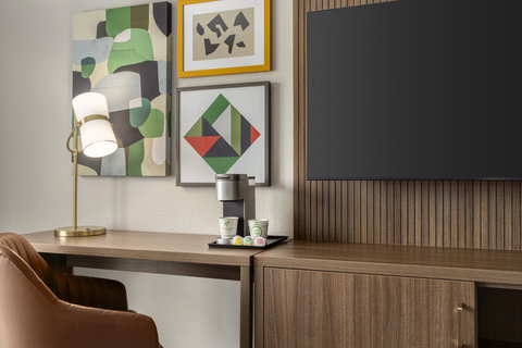 Work desk with an in-room coffee station and a flat screen TV.