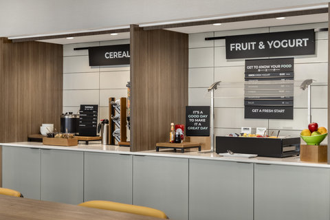 Breakfast buffet with cereal, fresh fruit, and yogurt station.