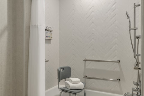 Accessible tub with grab bars and a handheld shower.