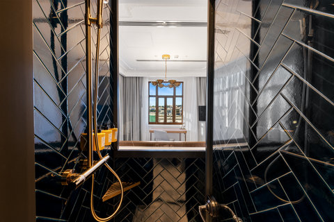 Refresh in a dark-tiled shower with premium amenities.
