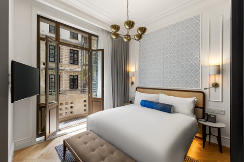 Rest easy on crisp white bedding beneath a warm brass chandelier