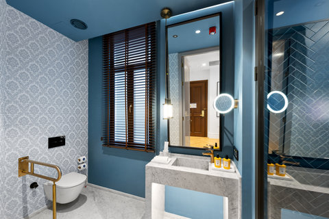 Freshen up in a lovely blue-tiled bathroom with marble vanity
