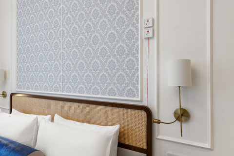 The rattan headboard and damask walls set the scene for your stay