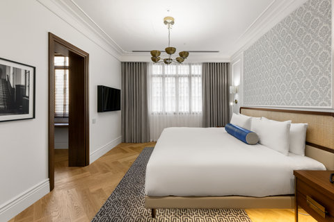 Sink into crisp bedding beneath brass lights and damask walls