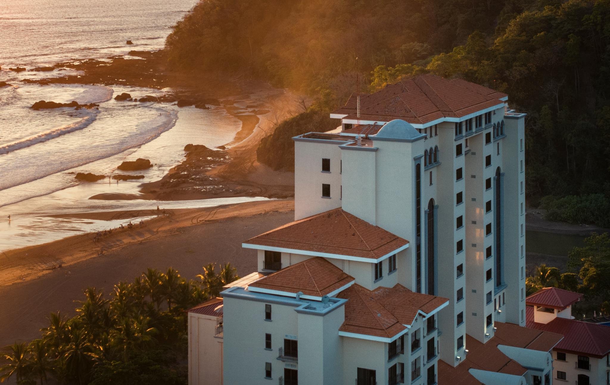 Crocs Resort and Casino-guestroom-Oceanfront resort with terracotta roofs at golden hour on a tropical beach.jpg