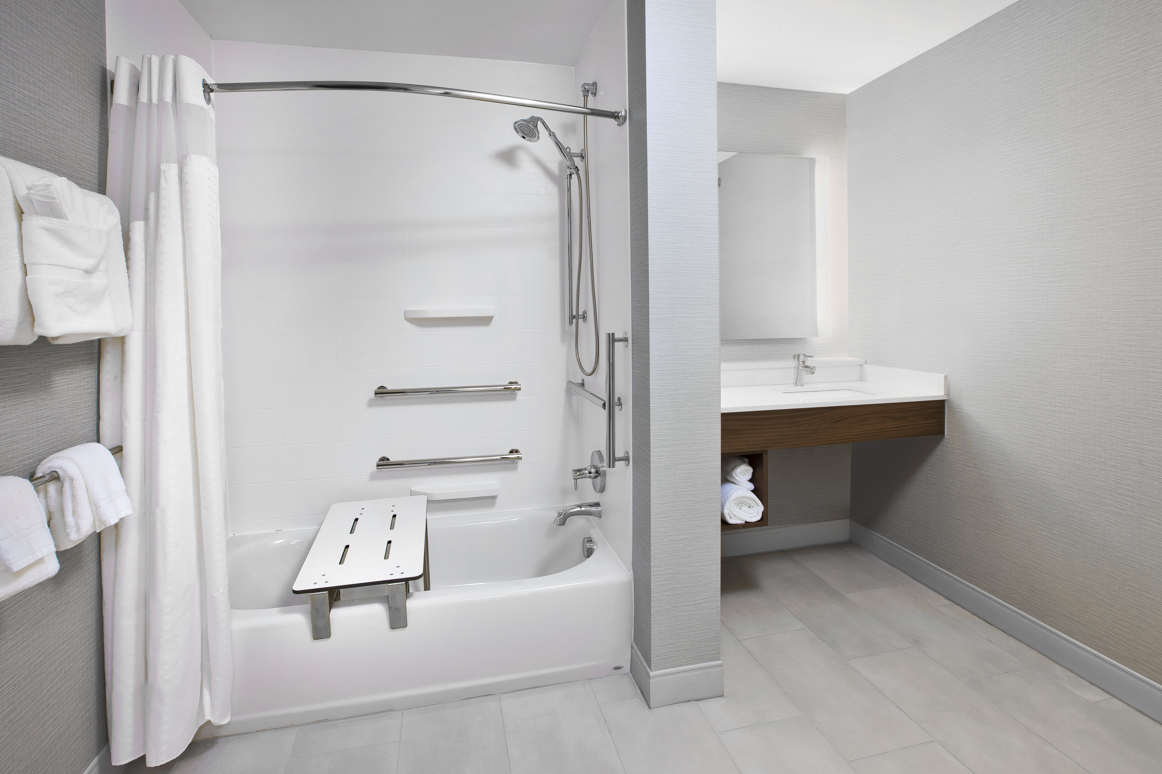 ADA compliant guest room with grab bars and adjustable shower.