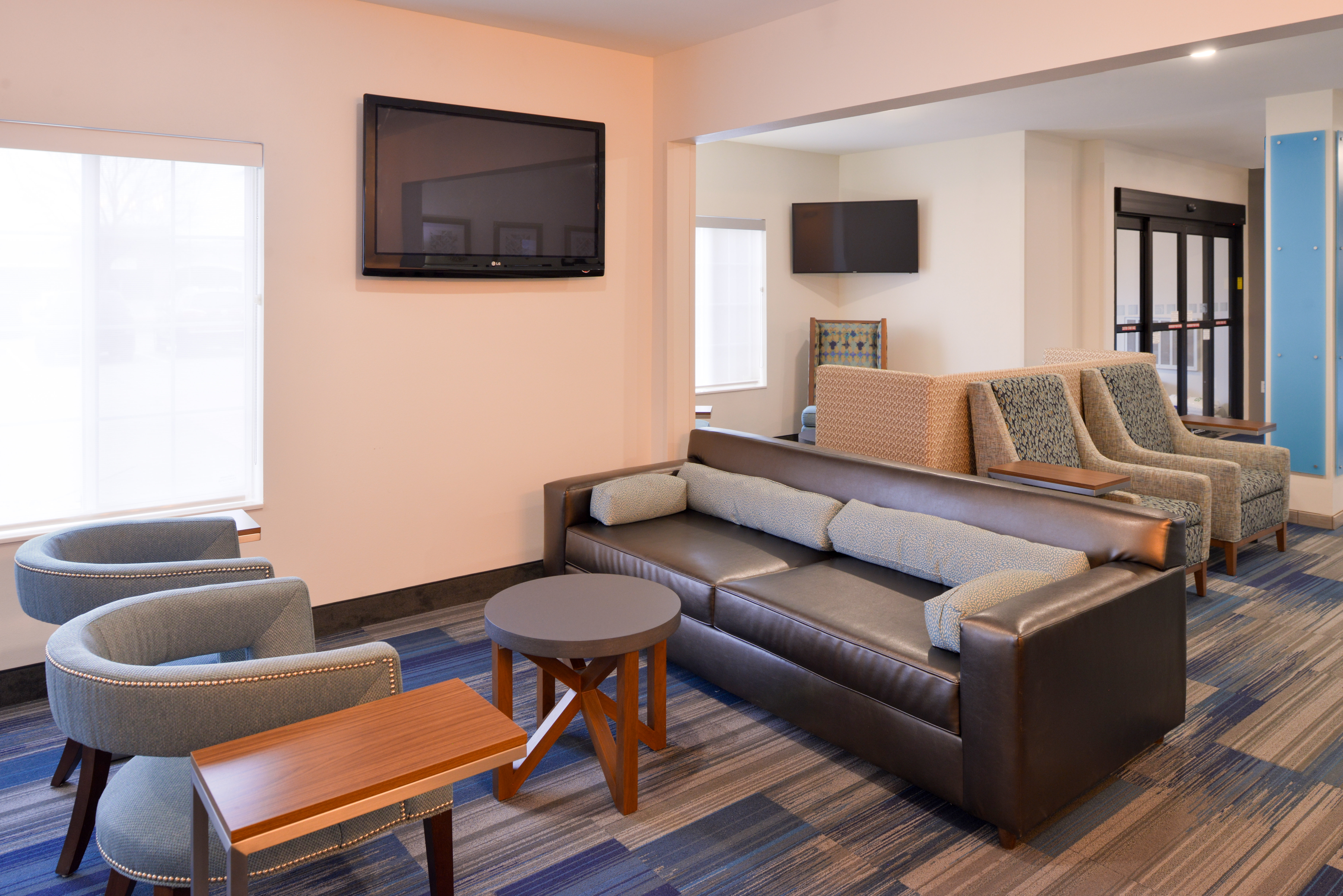Relax in Hotel Lobby featuring sofas & chairs and two televisions