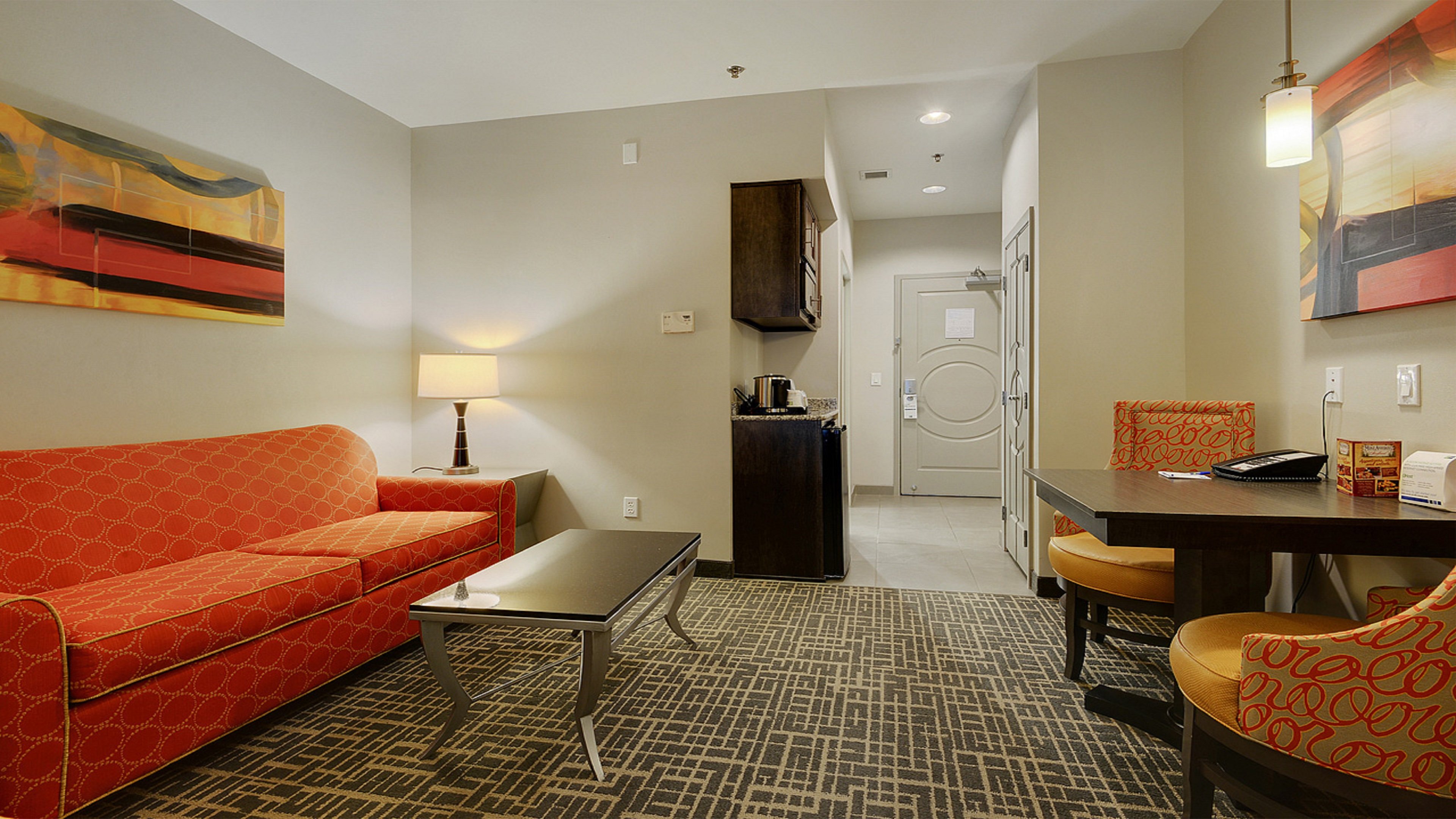 HOLIDAY INN EXP STES GONZALES BY IH-guestroom-Enjoy a spacious suite with a sofa bed and additional seating.jpg