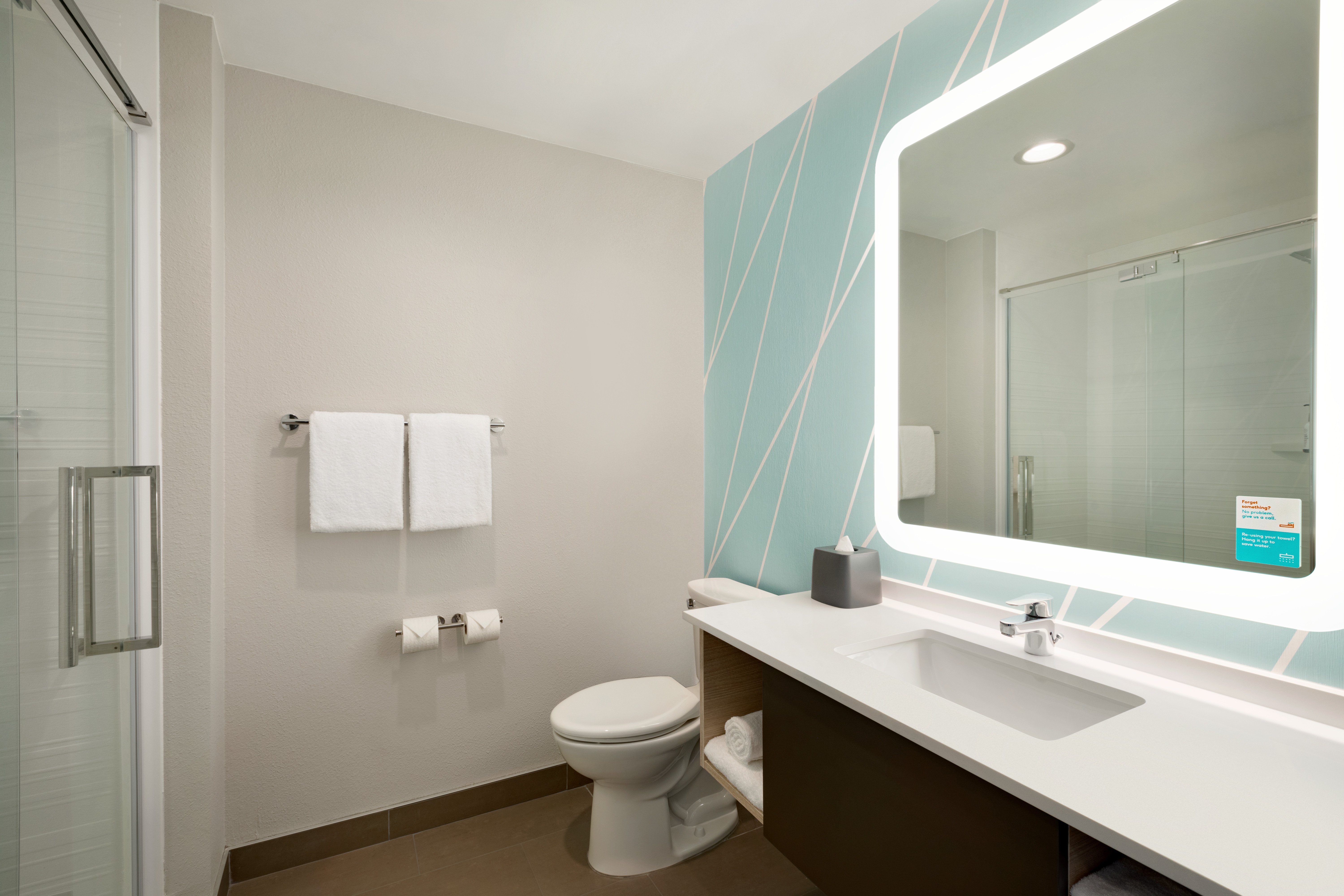 AVID HOTEL PERRY BY IHG-guestroom-A bright bathroom with large backlit mirror.jpg