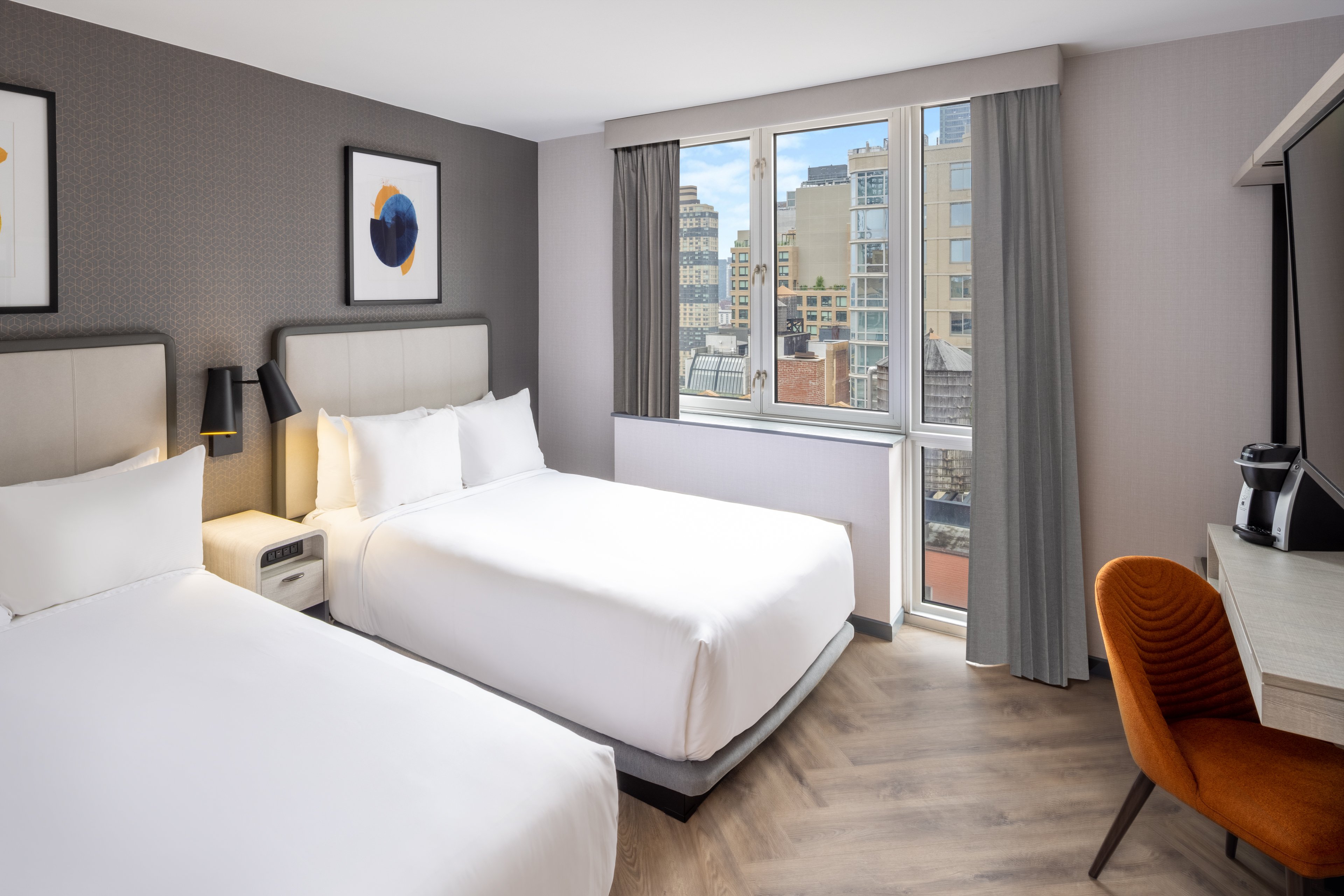 Renovated guest room with two double beds and views of Manhattan.