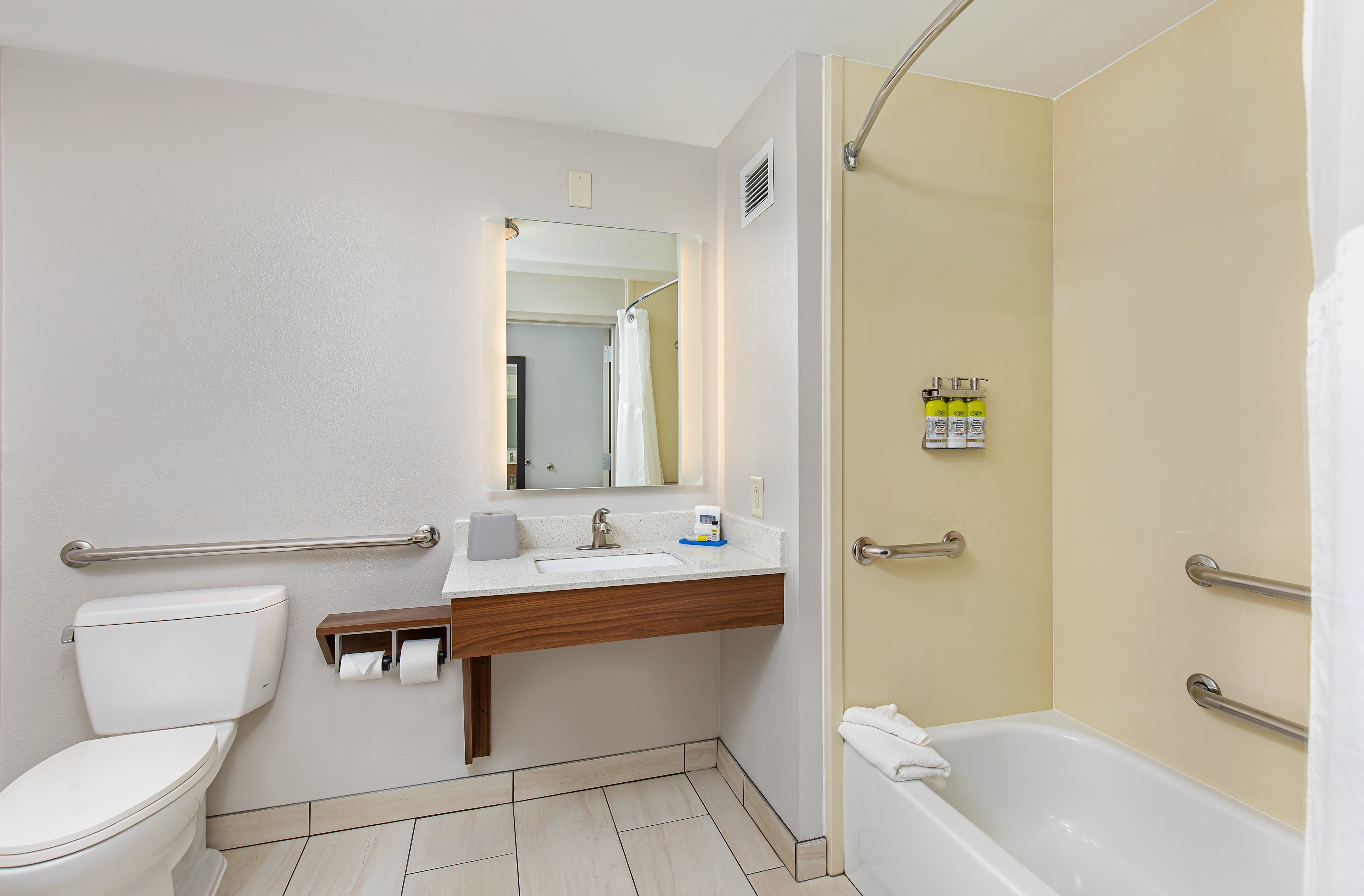 ADA Guest Bathroom with Handheld Shower and bulk shower amenities 