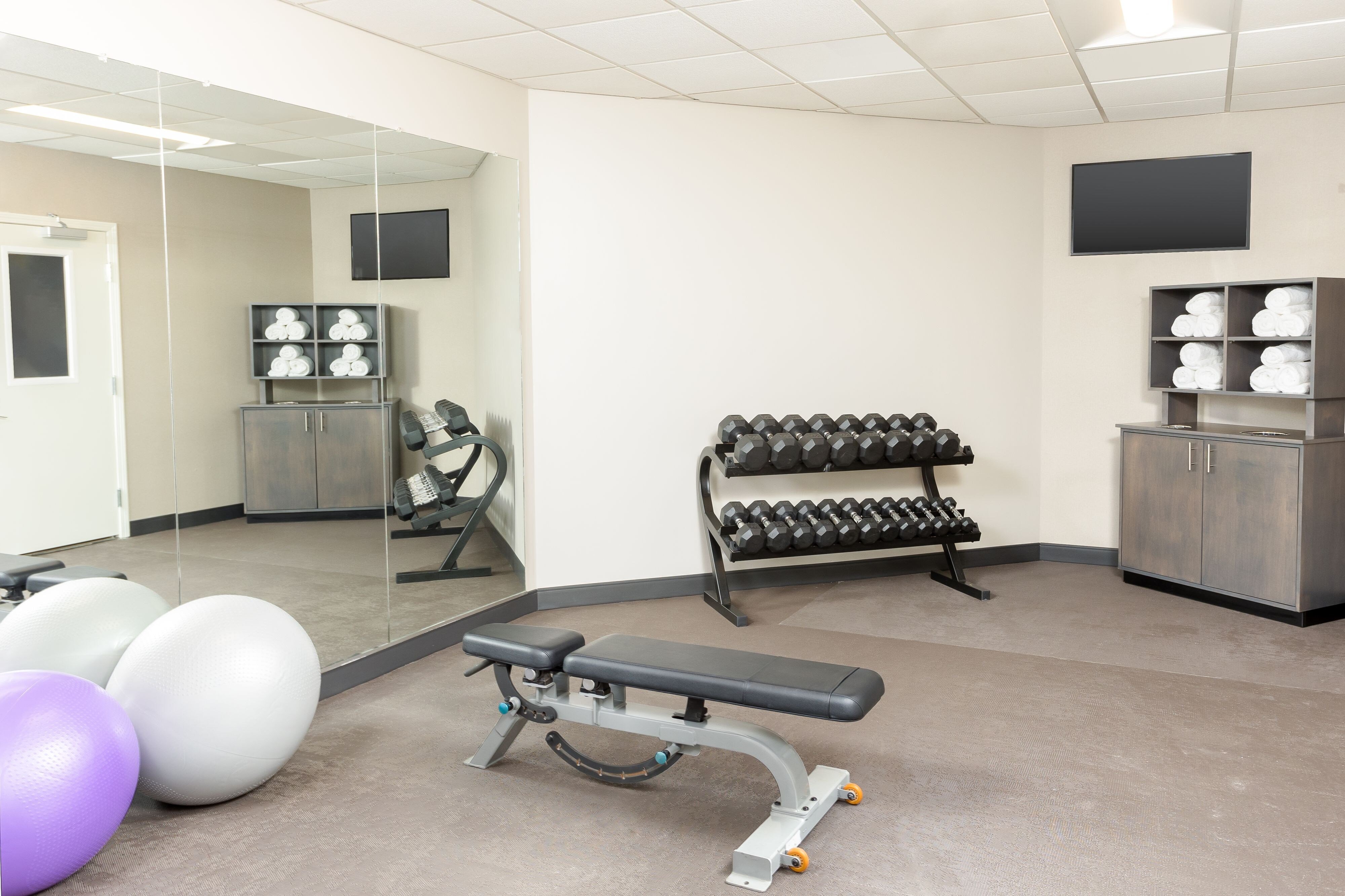 fitness center with bench, free weights and balls