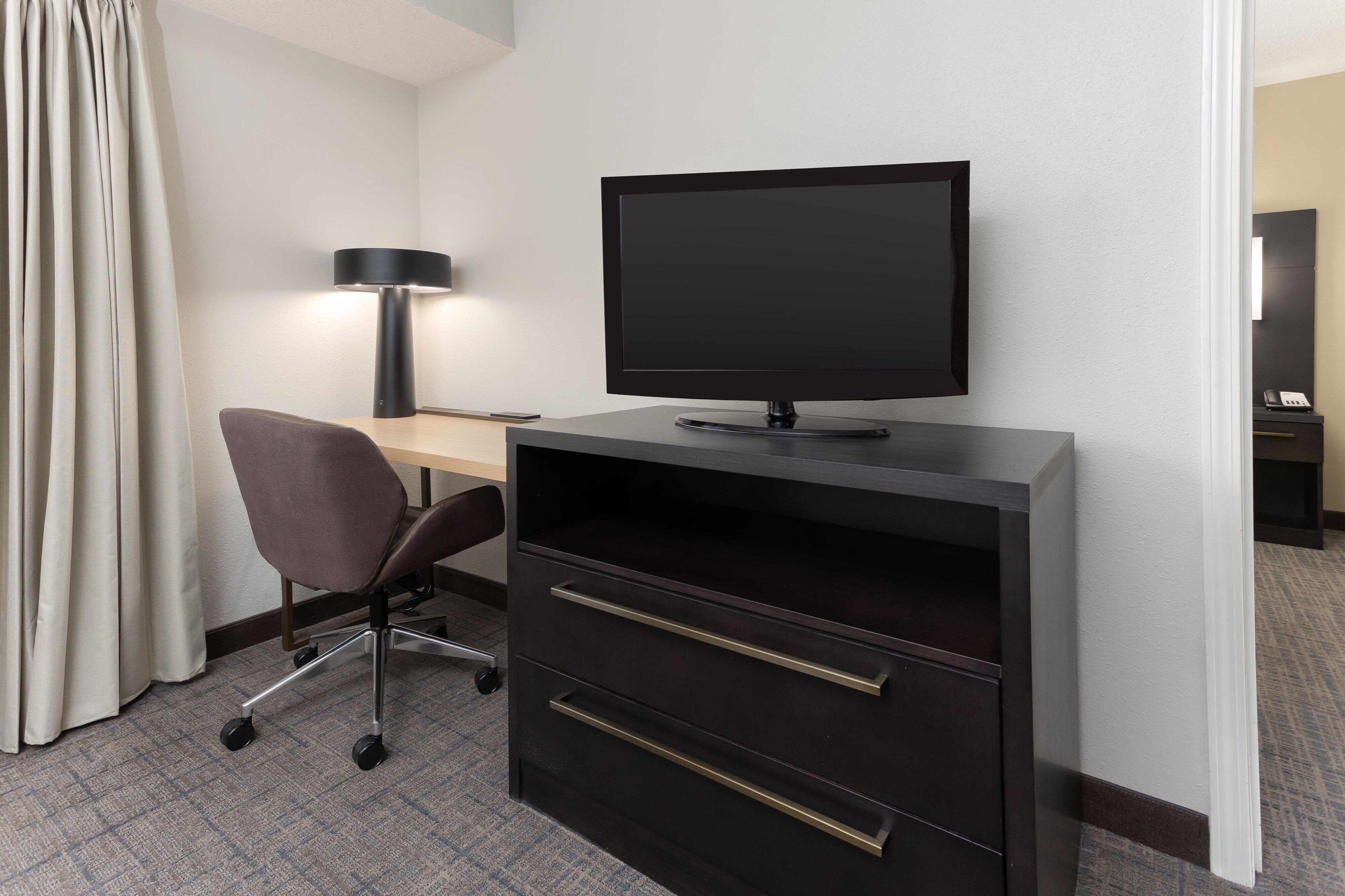 flat screen tv and work desk with lamp