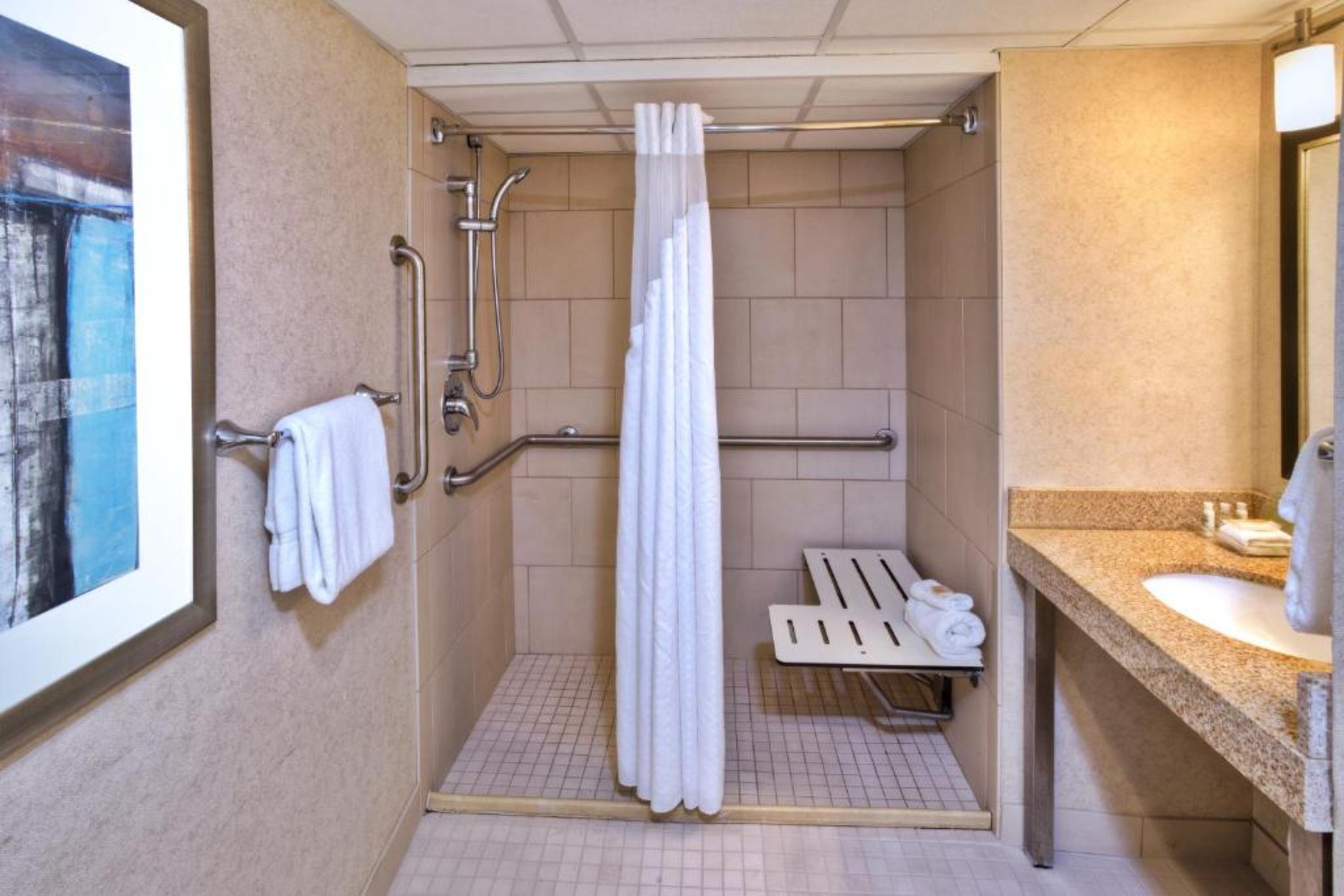 Accessible compliant bathroom with grab bars & roll in shower.